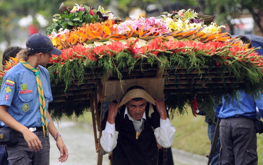 A man carries a flower arrangement on his black during the annual festival of flowers in Medellin, Colombia, Sunday, Aug. 11, 2013. The flower festival is one of the most important events of Medellin and has been celebrated every year since 1957. (AP Photo/Luis Benavides)